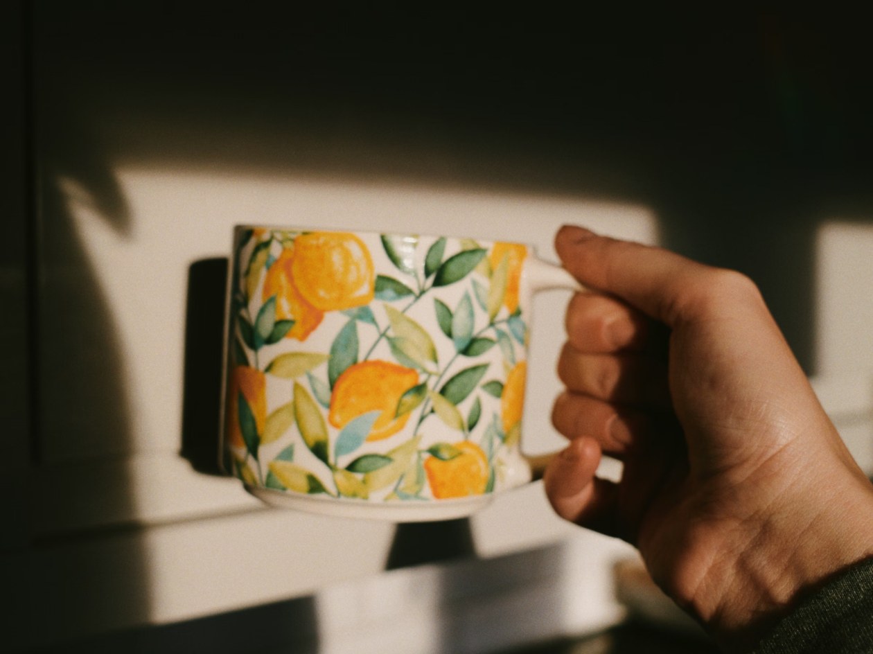 A floral mug and flowers on a quiet morning table